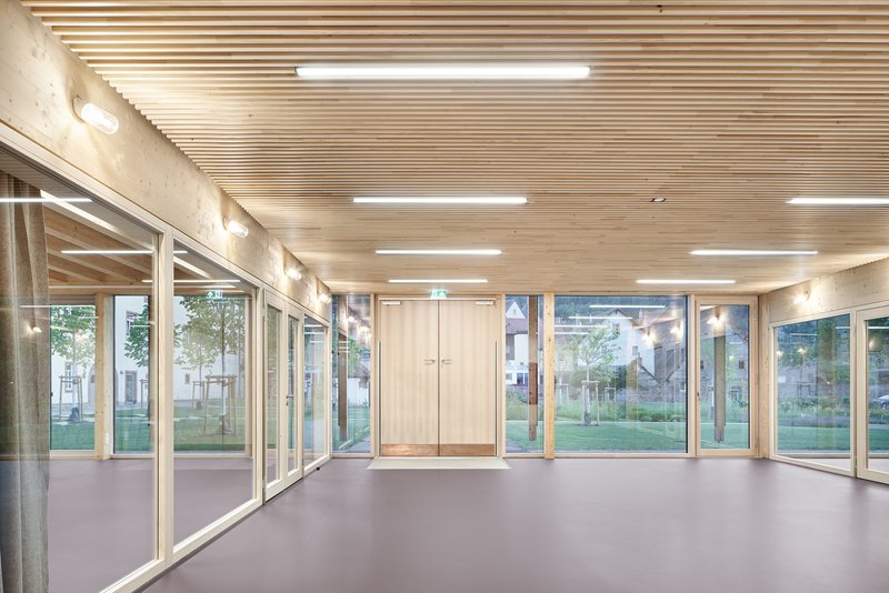 Interior corridor with slatted timber ceiling, glass walls and grey resin flooring