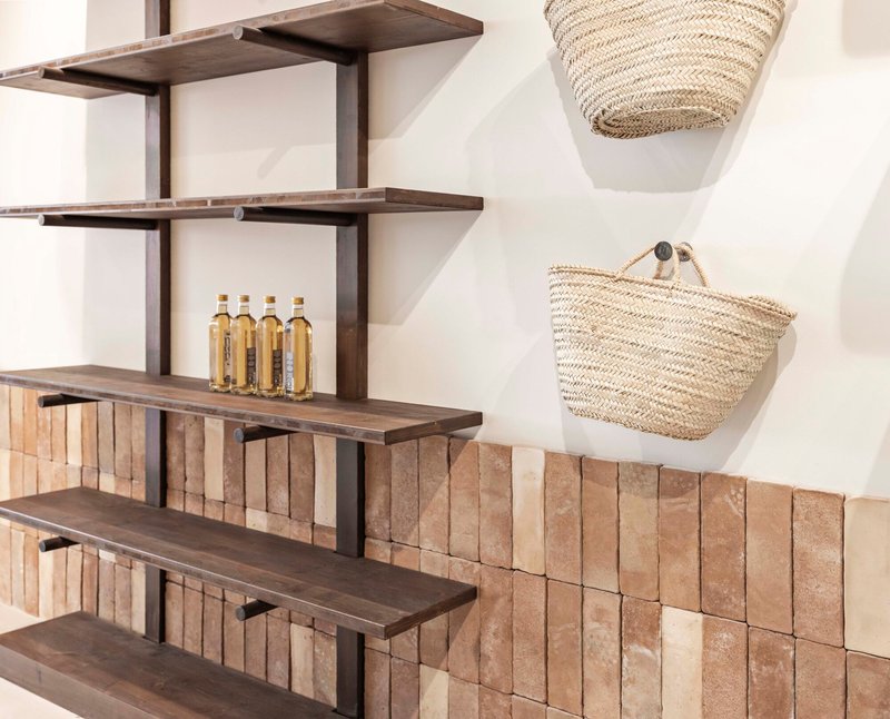 Dark timber shelves with vertical tile backsplash and hanging woven baskets on white wall