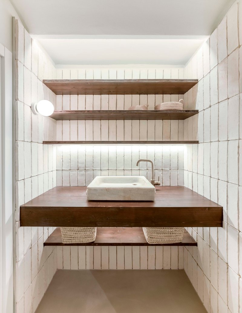 Compact washroom with white vertical tile walls and floating timber vanity with stone basin