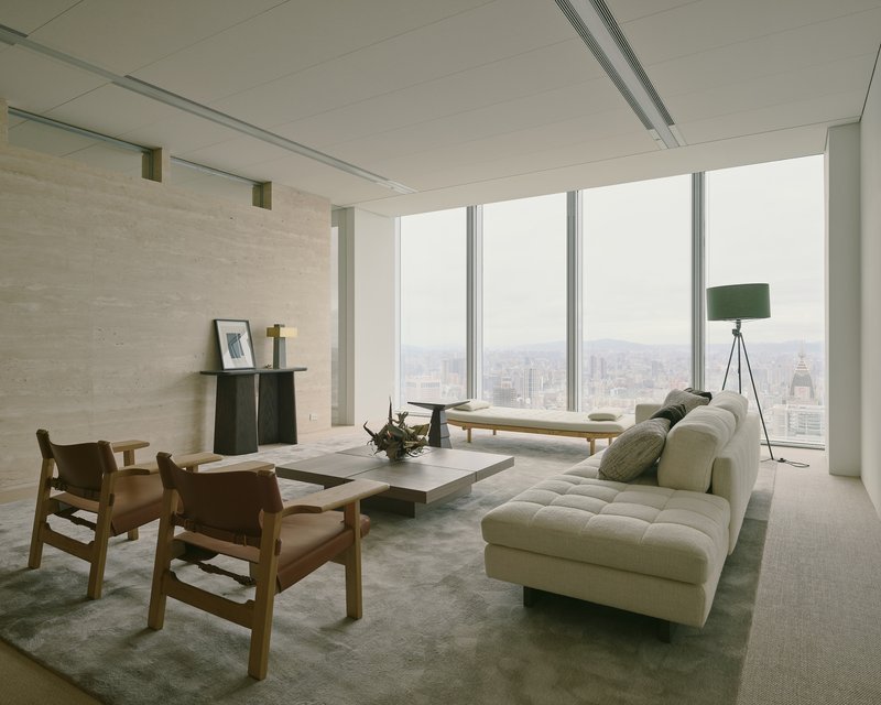 Corner room with floor-to-ceiling glazing overlooking the city skyline on an overcast day