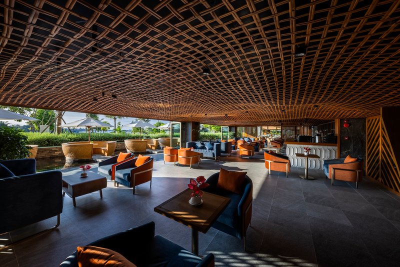 Lounge space with timber lattice ceiling and grouped seating looking onto terrace and landscaping