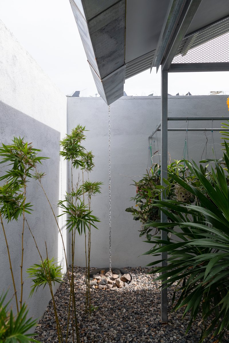 Corner courtyard with white painted walls, bamboo plants, and gravel ground cover