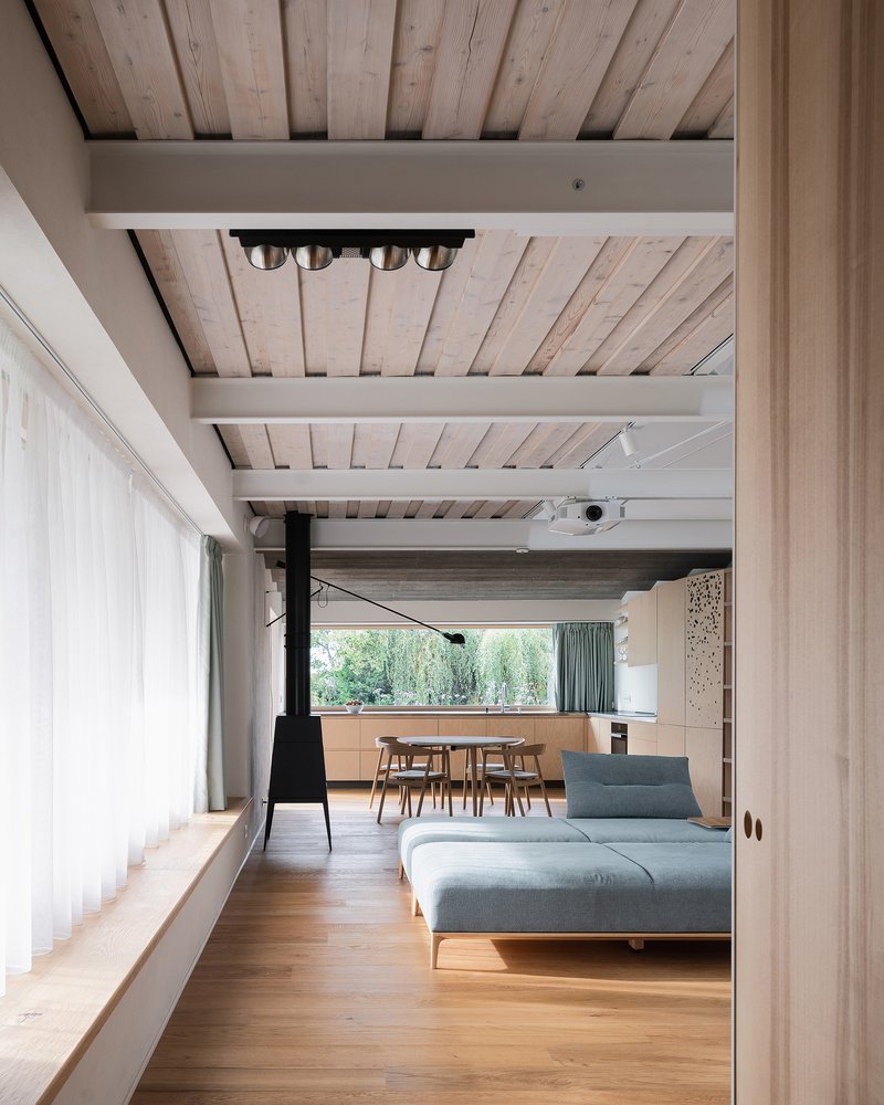 Living space with exposed timber ceiling beams, steel joists and oak flooring