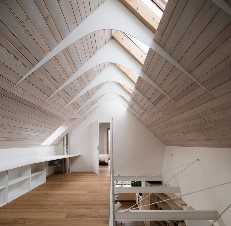 Attic space with timber-lined pitched ceiling, skylights and view through to bedroom