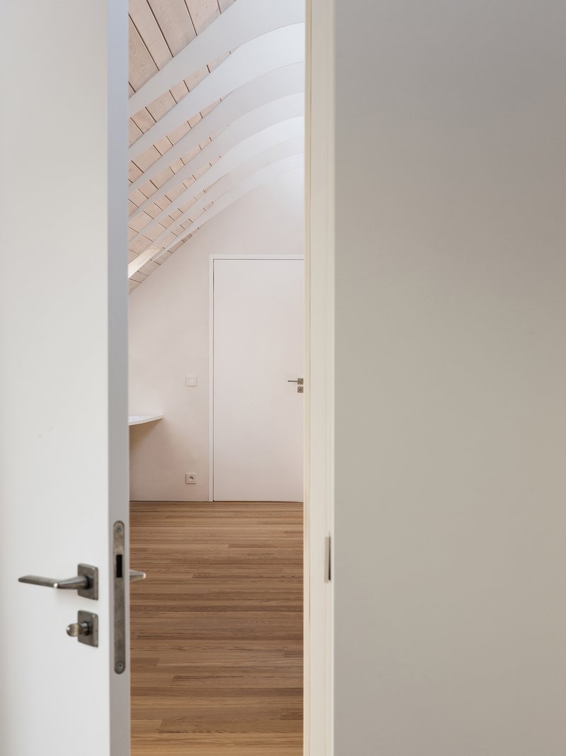 View through open doorways showing timber flooring and whitewashed timber slat ceiling under pitched roof
