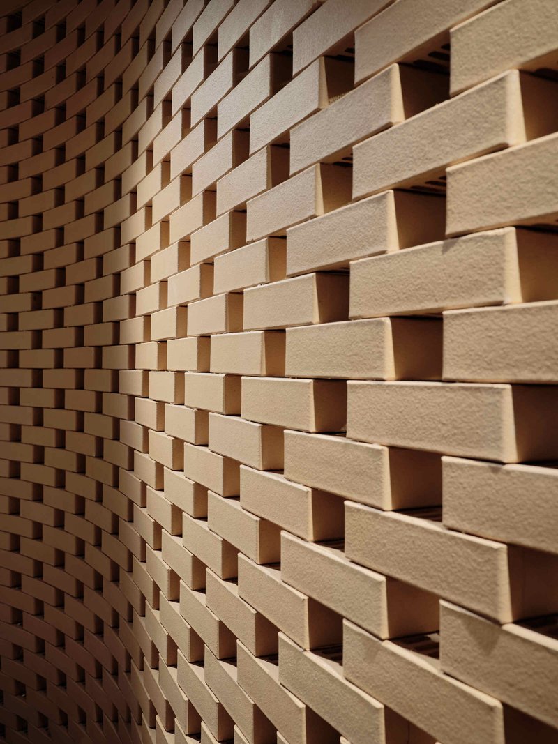 Close-up of staggered timber brick wall creating a basketweave pattern with recessed shadow gaps
