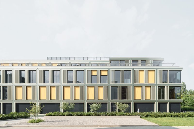 Long elevation at dusk with interior lights illuminating the office floors behind the grid facade