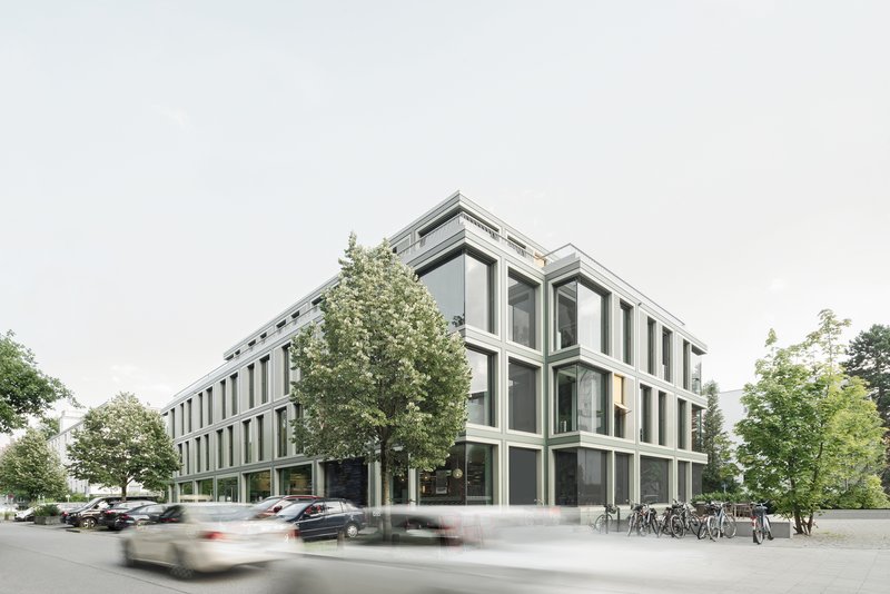Street corner view of the framed facade with vertical fin mullions and passing traffic