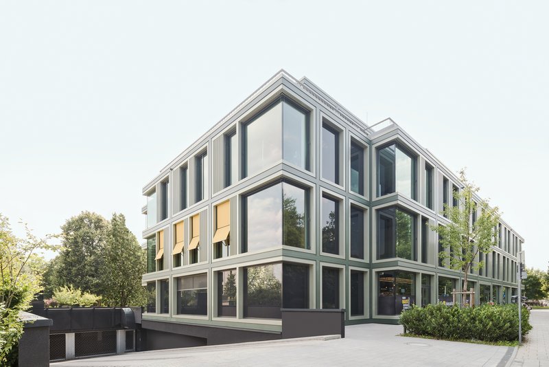 Facade composition with recessed glass panels framed by light-colored mullions and dark ground floor base