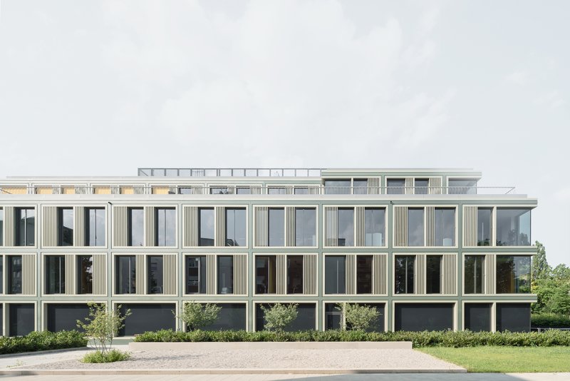 Long elevation showing repetitive grid of windows with vertical fin detailing and planted landscape below