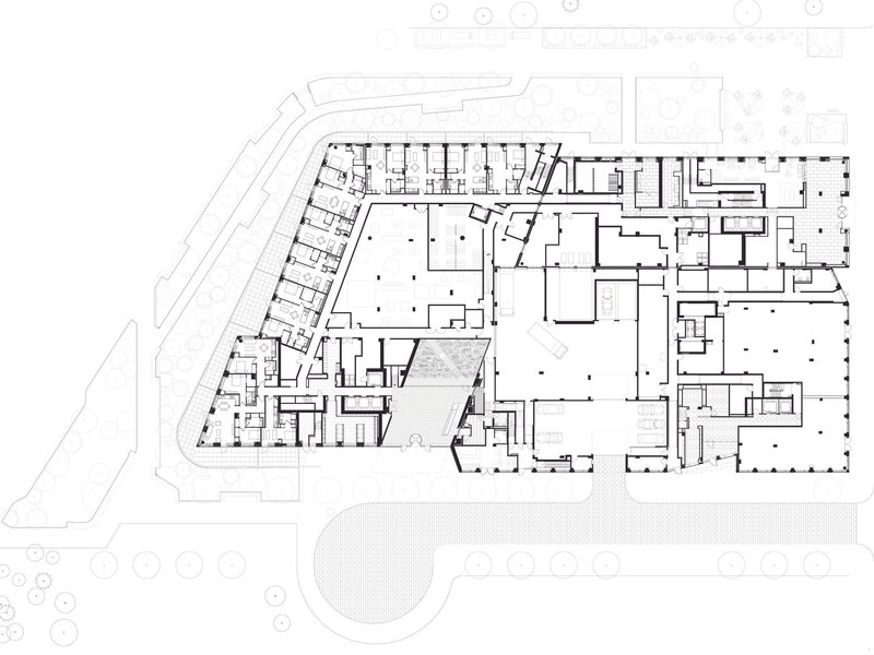 Floor plan drawing showing an angular complex with multiple courtyards and a curved roadway along one edge