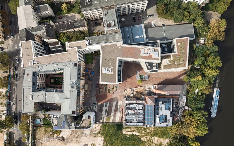Aerial view of the terracotta roof courtyard surrounded by mixed development in summer