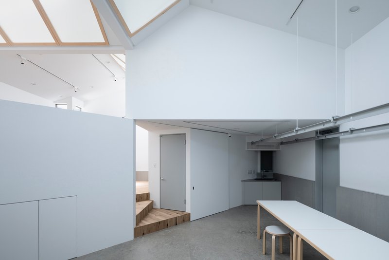 Open kitchen and dining area with exposed ductwork and timber-framed skylights above