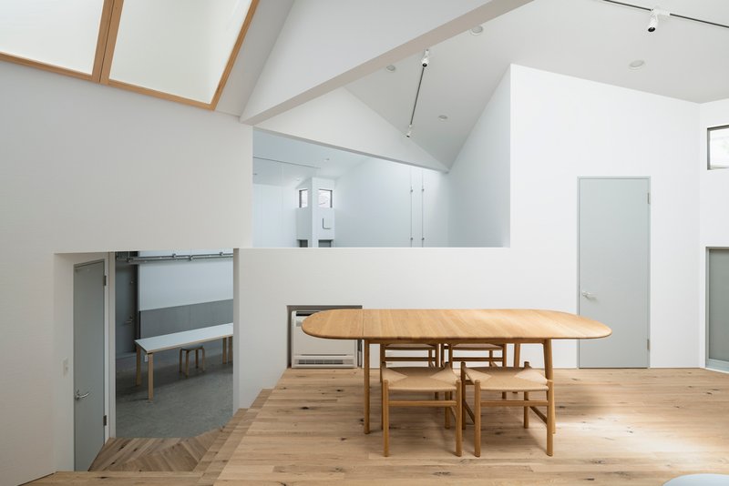 Mezzanine dining area with timber flooring overlooking the lower level concrete floor and sliding door below
