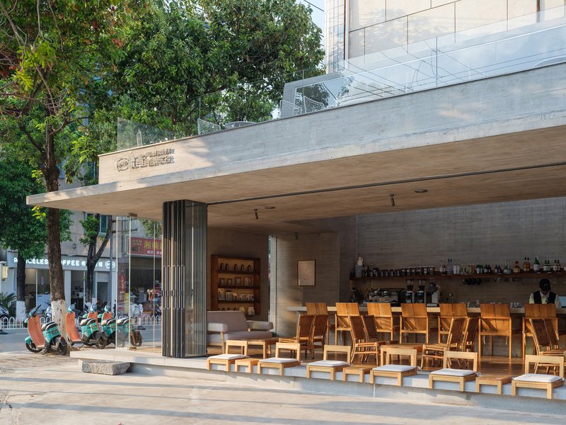 Covered outdoor seating area with timber furniture and concrete canopy with wood soffit