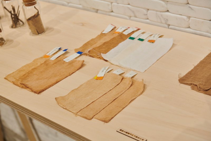 Plywood table displaying paper or textile samples with colored tabs arranged in rows