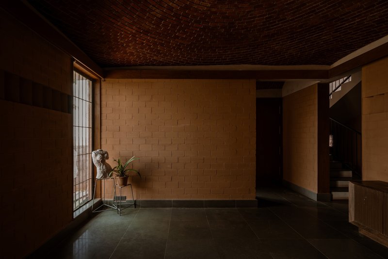 Entry hall with basket-weave brick vaulted ceiling and woven block walls in soft afternoon light