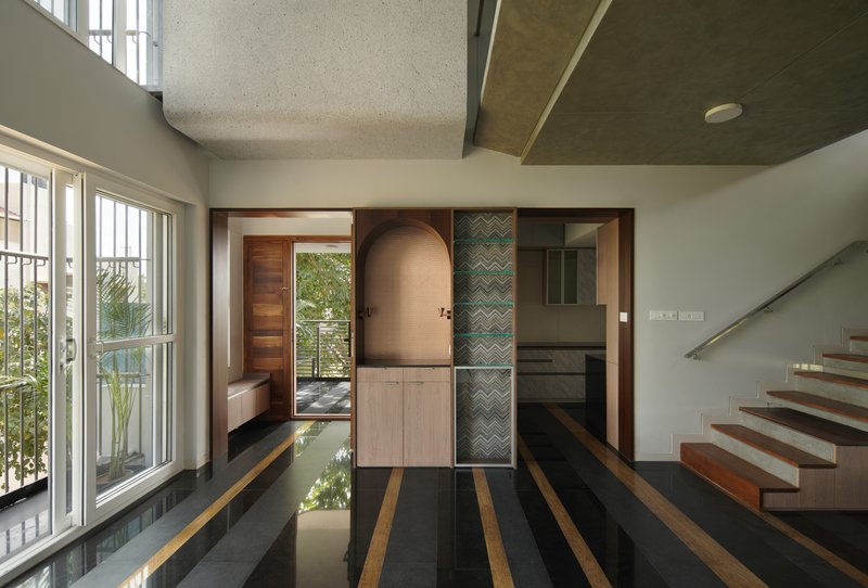 Double-height interior with striped black and tan flooring leading to a curved arched doorway
