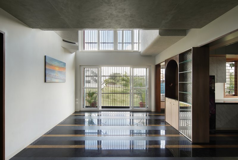 Interior with polished striped floor reflecting light from vertical louver windows overlooking the landscape