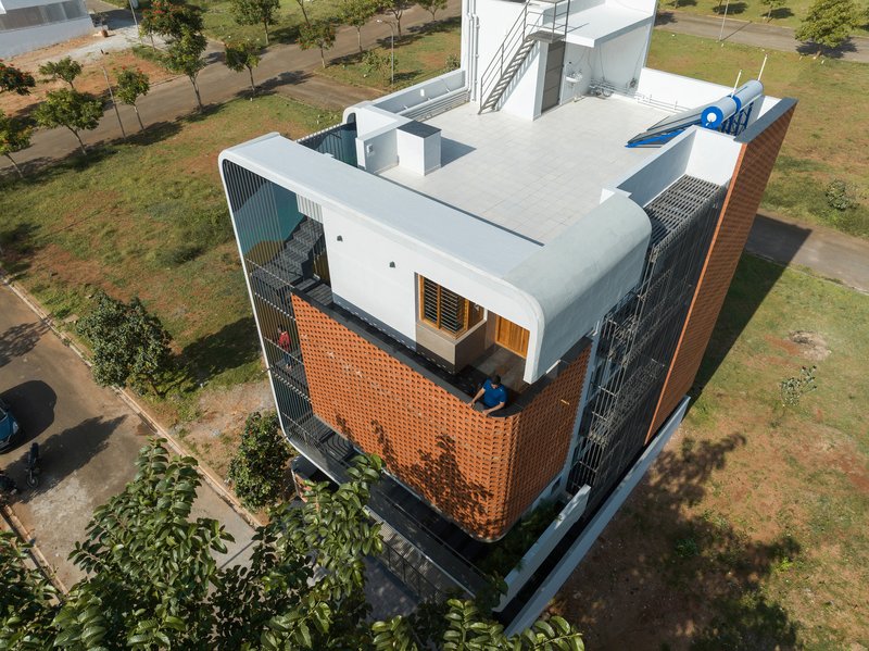 Aerial view of the rooftop terrace with solar panels and adjacent perforated brick screen