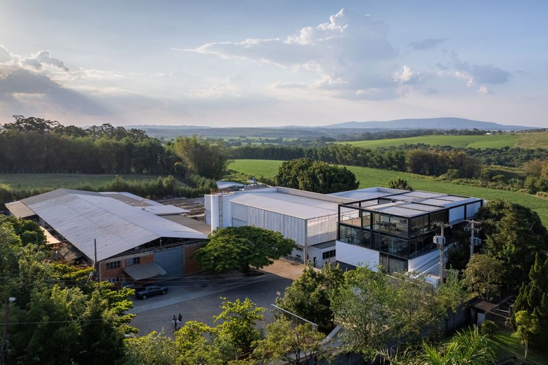 Aerial view of the industrial complex with metal roofs surrounded by green fields and trees