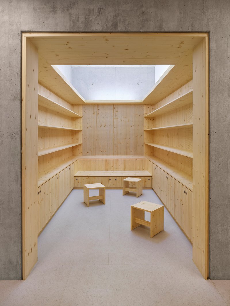 View into a small timber-lined reading nook with built-in shelves and a skylight