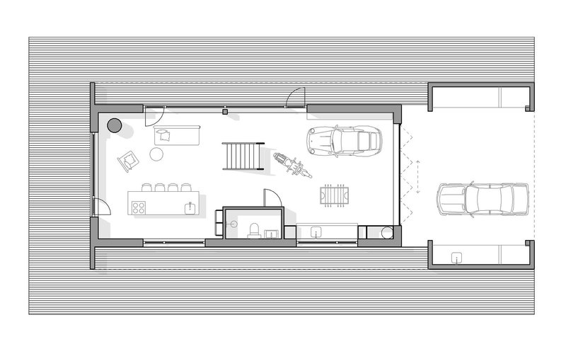 Floor plan drawing showing open living area, motorcycle, vehicle parking, and stair to upper level