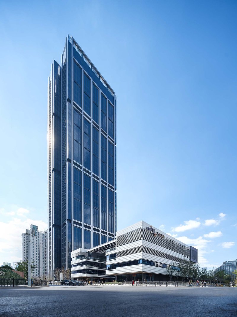 Street-level view of the glass tower rising above a horizontal podium with pedestrians on the plaza
