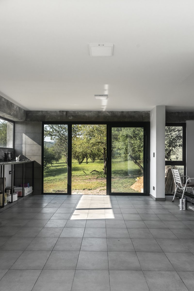 Open living space with gray tile floor and sliding glass doors opening to garden