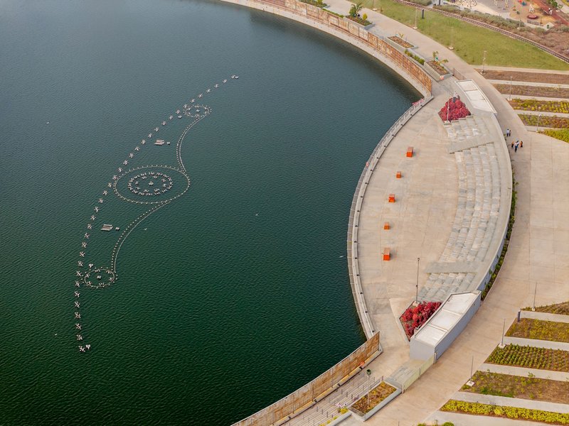 Overhead view of the curved amphitheater seating adjacent to the water with floating light installation