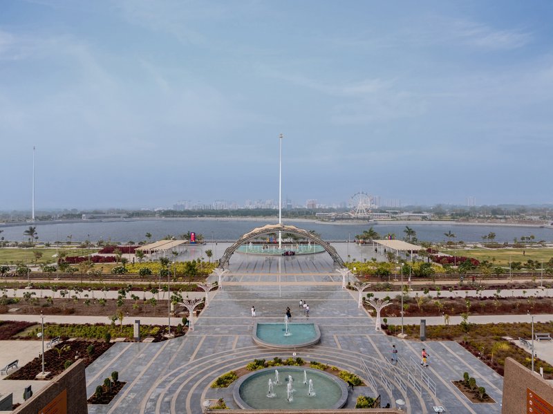 Central axis looking toward the arched canopy structure with circular fountains and terraced landscaping beds