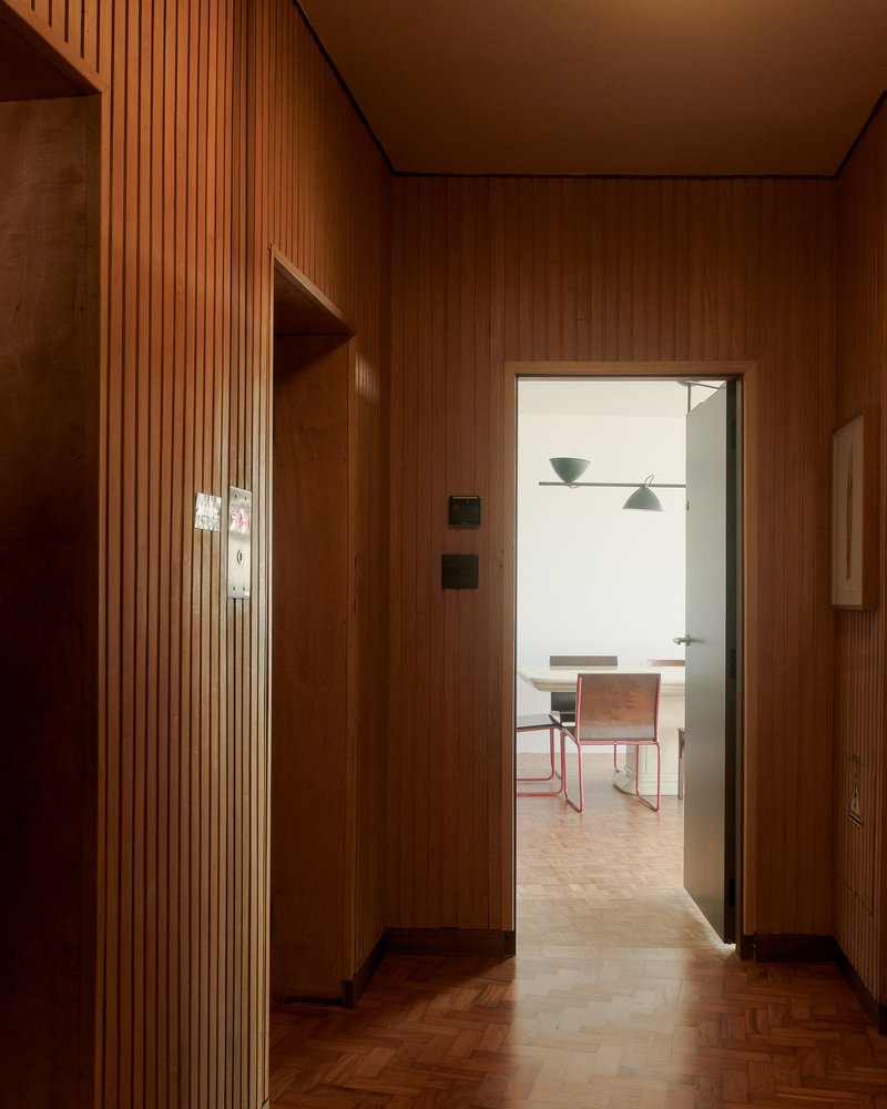Hallway with vertical timber slat wall and herringbone parquet floor leading to dining area
