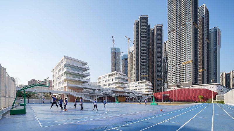 Blue basketball court with students playing in front of white terraced building and highrise towers