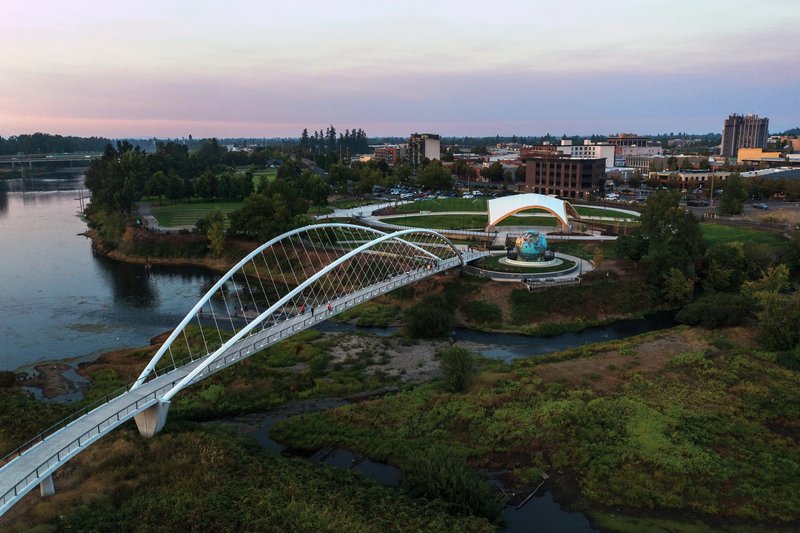 Drone view of the cable-stayed footbridge crossing wetlands and waterways at dusk