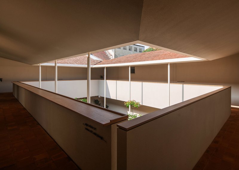 Interior courtyard viewed from an upper corridor with timber bench and planted bed below