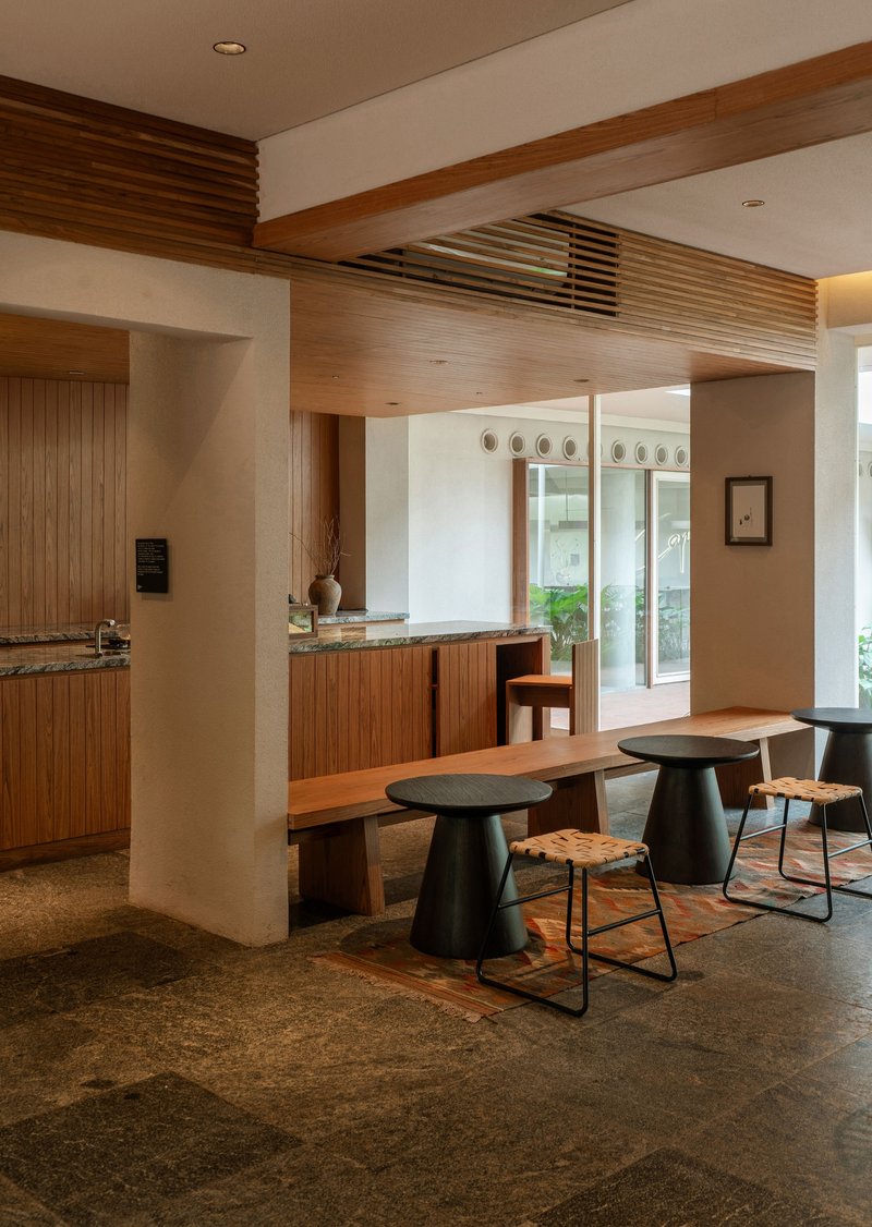 Open kitchen and dining space with ribbed timber cabinetry and dark terrazzo flooring