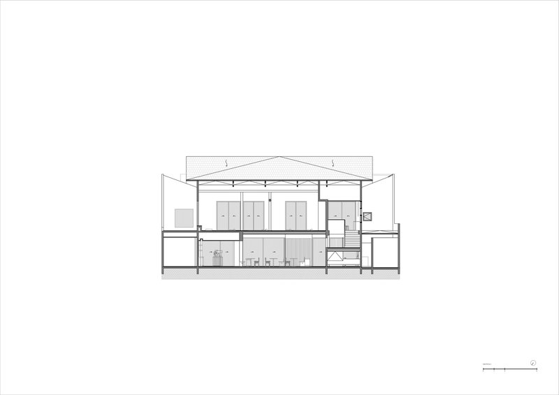 Section drawing revealing a two-story volume with exposed ceiling structure and interior partitions