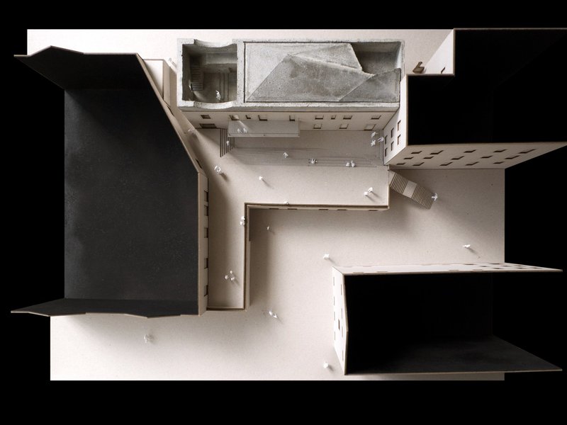 Top-down view of a physical model showing an interior courtyard with small figures and surrounding rooms