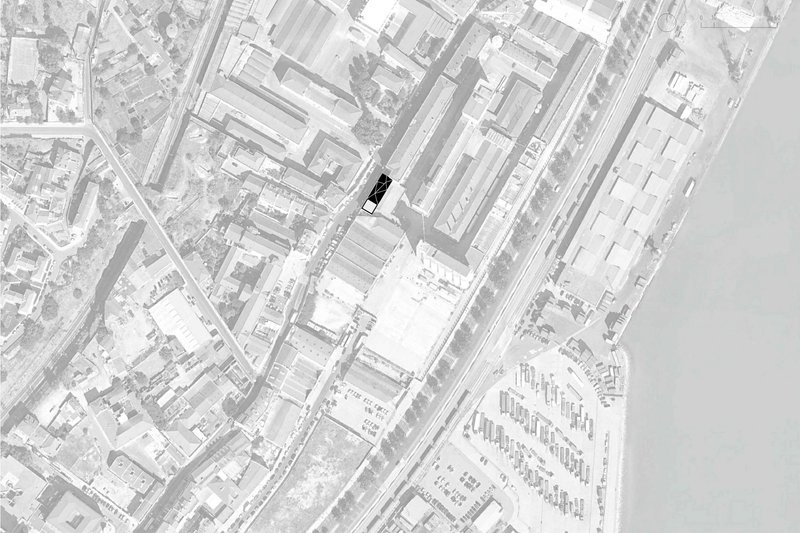 Site plan drawing showing a single building footprint highlighted in black within a dense urban block