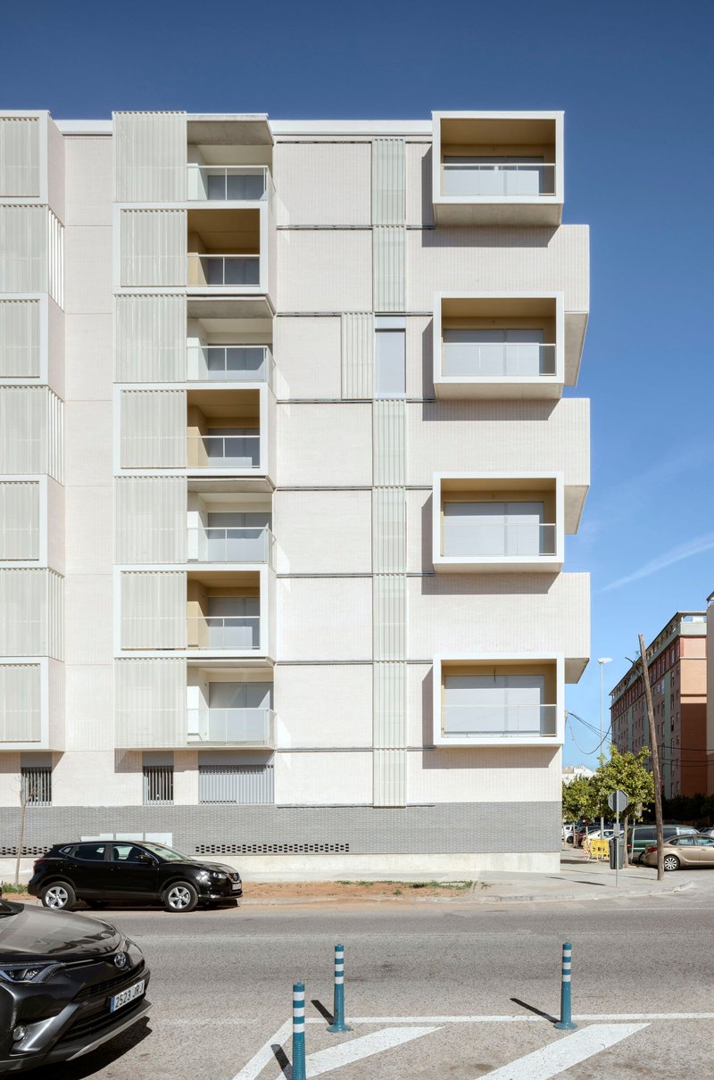 Elevation showing alternating recessed and cantilevered balconies with white panel and ribbed metal cladding