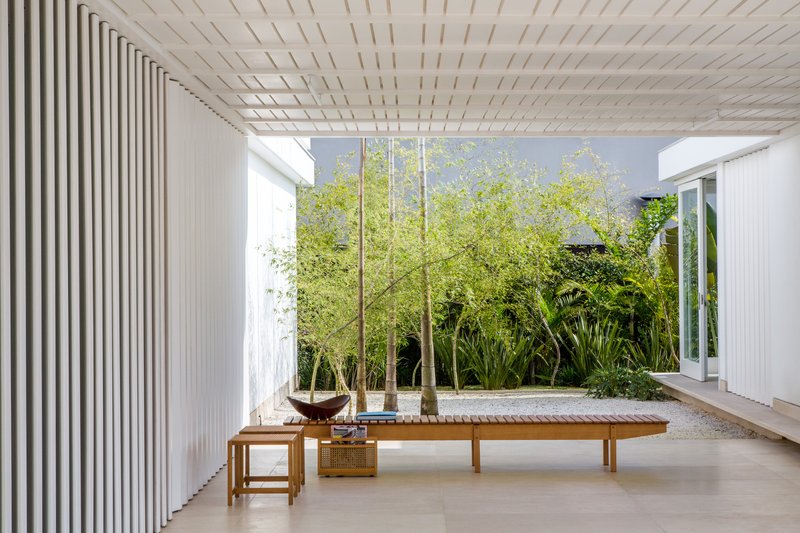 Interior courtyard with timber lounge and vertical slat screen wall under a slatted timber ceiling