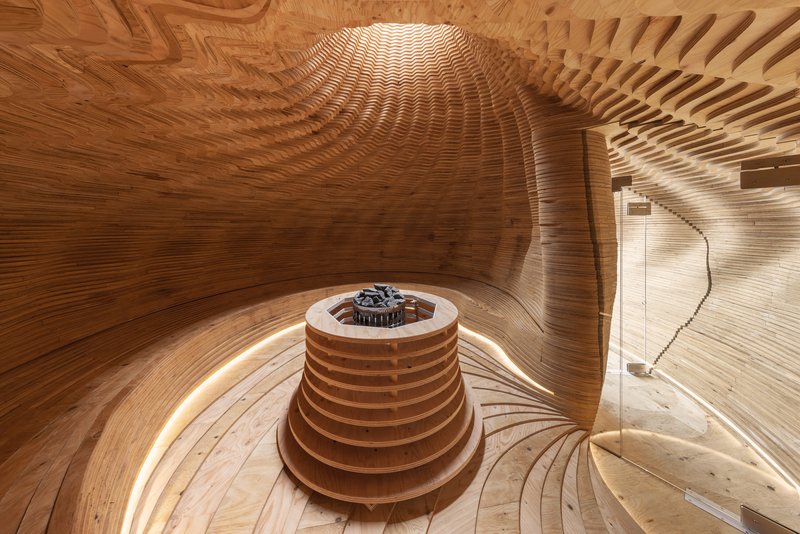 Interior view of the laminated wood sauna chamber with central heater and radial benches