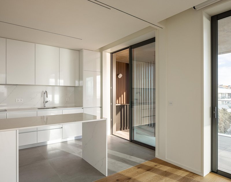 Kitchen opening onto balcony with timber slat screen visible through glazed door