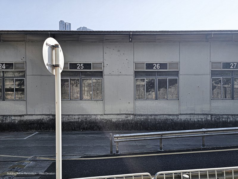 Concrete facade with numbered bays and horizontal ventilation grilles beneath an overcast sky