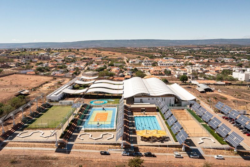 Aerial view of the sports complex with curved roofs and solar panel arrays in the arid landscape
