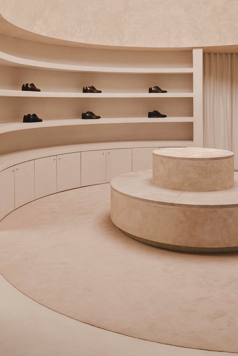 Close-up of the limestone-clad display podium with curved shelving along the perimeter wall
