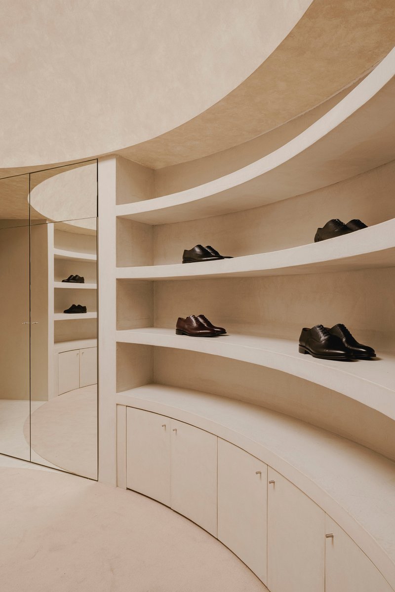 Detail of the curved shelving with mirrored cabinet and flowing ceiling soffit overhead