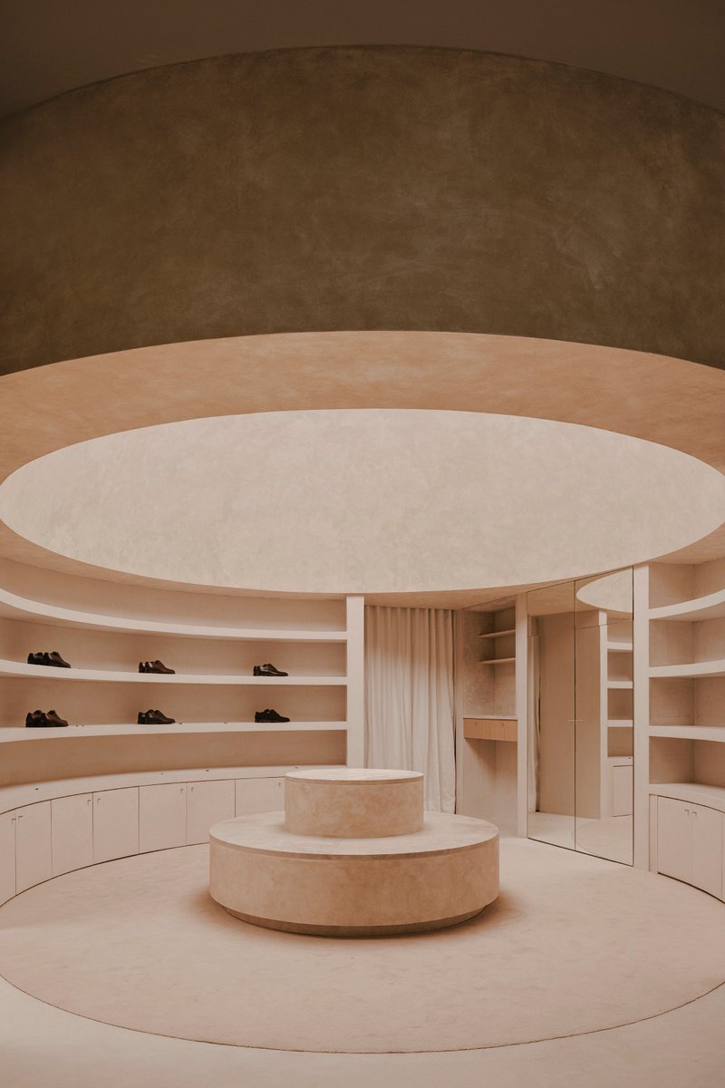 View of the cylindrical stone display podium beneath concentric ceiling rings with integrated lighting