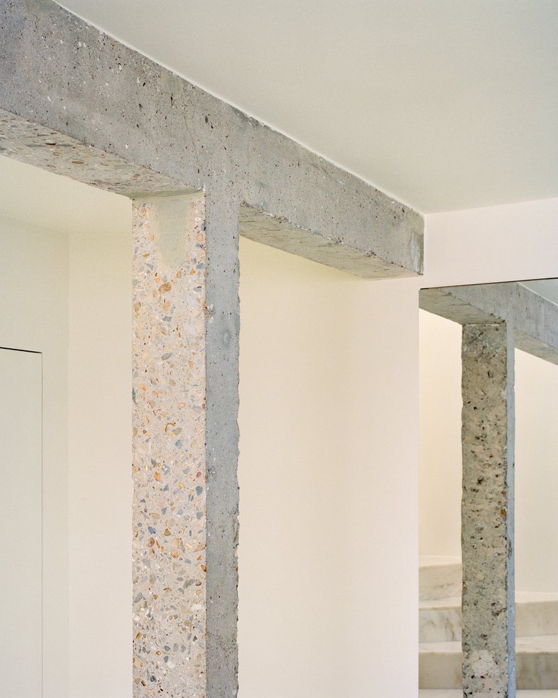 Terrazzo columns and beam junction showing aggregate texture against pale painted walls