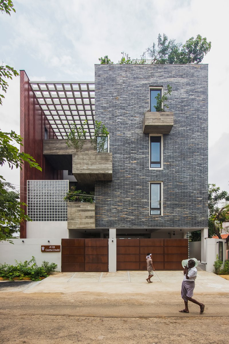 Front elevation showing staggered concrete balconies and timber grid pergola with two pedestrians passing